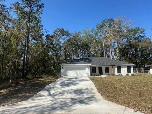 single story home featuring a garage, concrete driveway, and a front yard