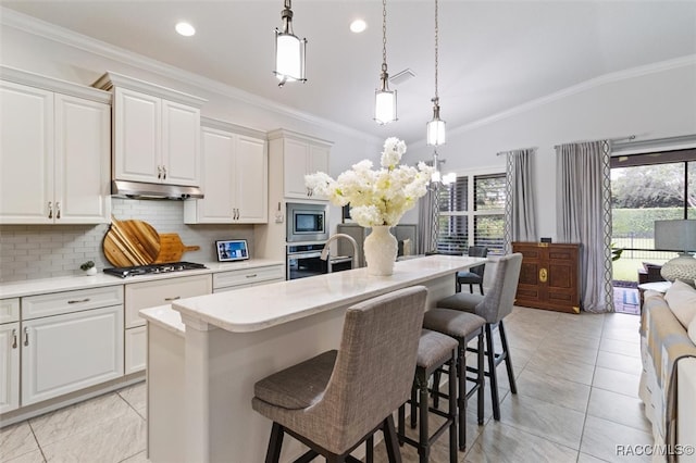 kitchen featuring pendant lighting, a center island with sink, stainless steel appliances, and vaulted ceiling