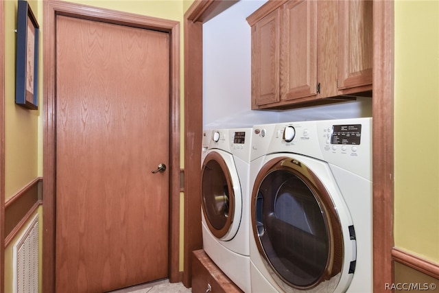 washroom with cabinets and washer and dryer