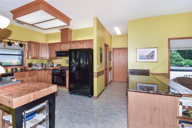 kitchen featuring black appliances, light tile patterned floors, kitchen peninsula, and wine cooler