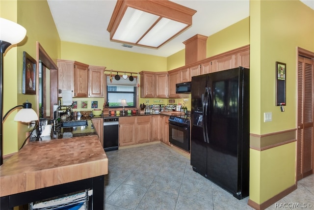 kitchen featuring light tile patterned floors, sink, and black appliances