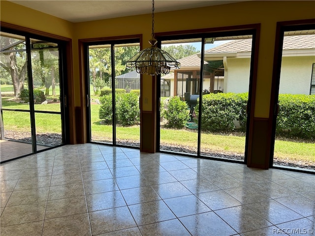 doorway featuring tile patterned flooring and a chandelier