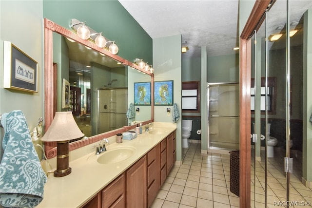 bathroom featuring tile patterned floors, vanity, toilet, and walk in shower