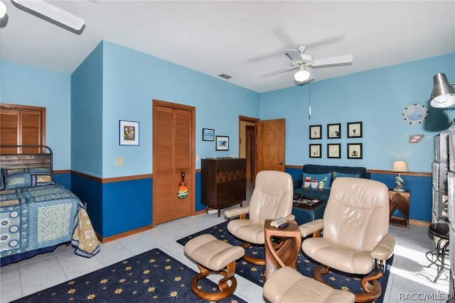 tiled bedroom featuring ceiling fan and a closet