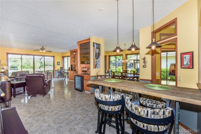 dining space with ceiling fan and wine cooler