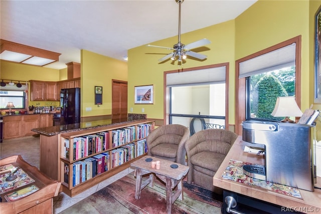 tiled living room featuring ceiling fan and lofted ceiling