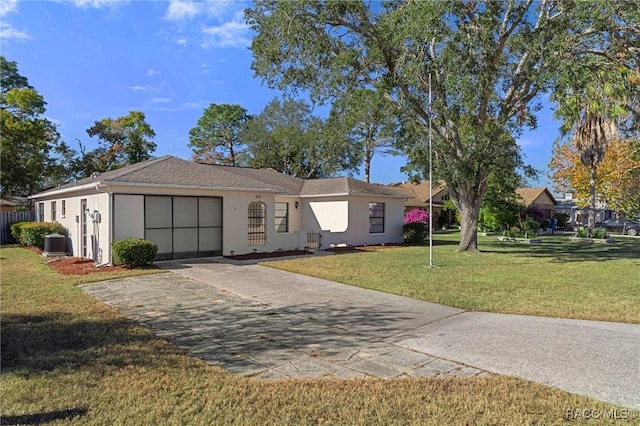 single story home featuring central AC unit, a front yard, and a garage