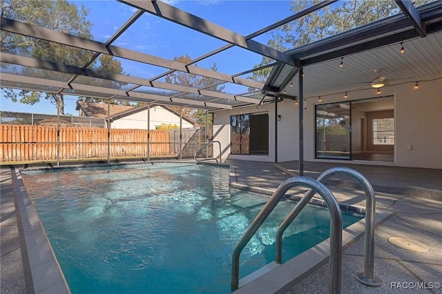 view of swimming pool featuring ceiling fan, a lanai, and a patio