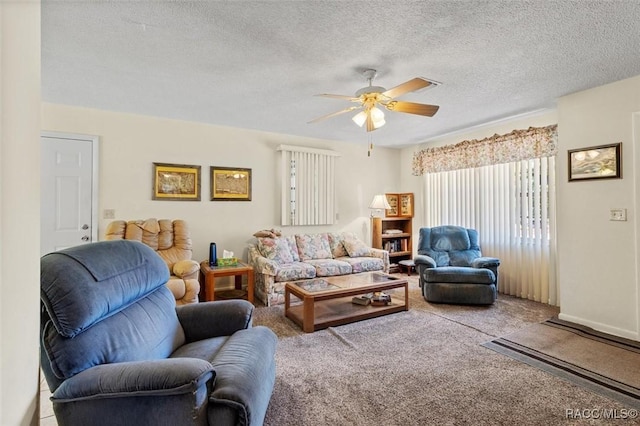 living area featuring carpet floors, a ceiling fan, and a textured ceiling