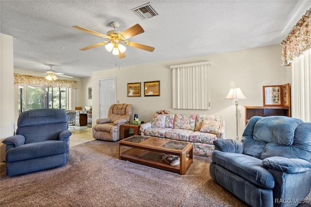 living room with carpet flooring, visible vents, a textured ceiling, and a ceiling fan