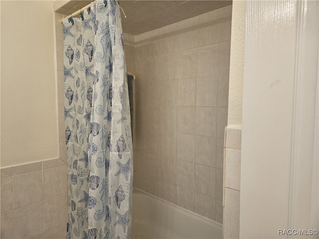 7781 N Lazy Trl, Crystal River, FL 34428 - full bath with shower / bathtub combination with curtain, tile walls, and wainscoting