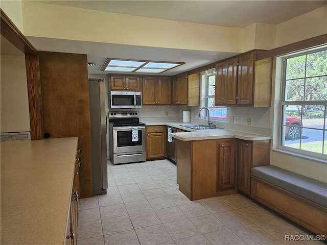 7781 N Lazy Trl, Crystal River, FL 34428 - kitchen featuring appliances with stainless steel finishes, a sink, light countertops, a peninsula, and decorative backsplash