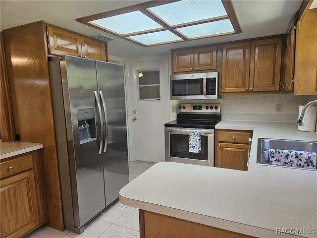 7781 N Lazy Trl, Crystal River, FL 34428 - kitchen featuring appliances with stainless steel finishes, a sink, light tile patterned floors, light countertops, and brown cabinetry