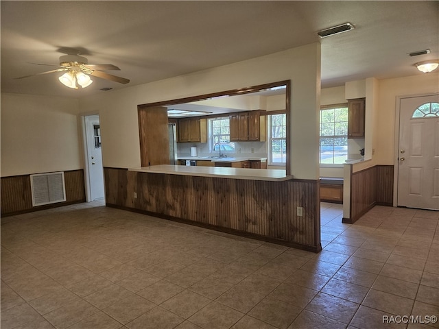 7781 N Lazy Trl, Crystal River, FL 34428 - kitchen featuring wainscoting, a peninsula, a sink, light countertops, and a ceiling fan