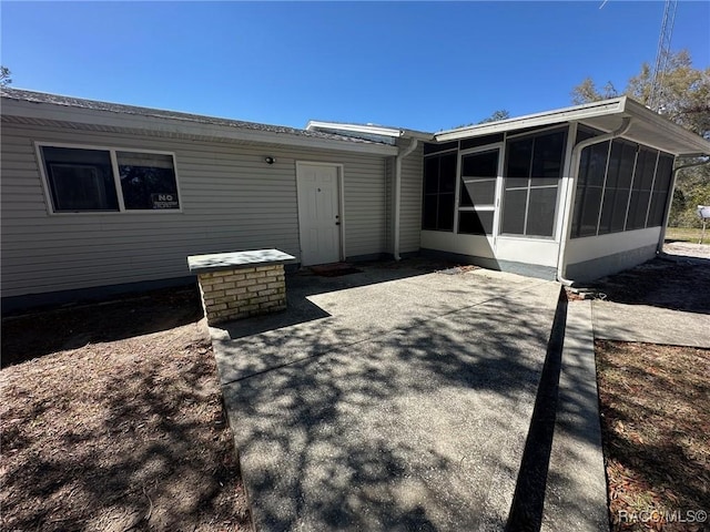 rear view of property with a patio and a sunroom