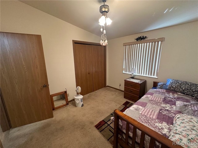 bedroom with lofted ceiling, a closet, and carpet floors