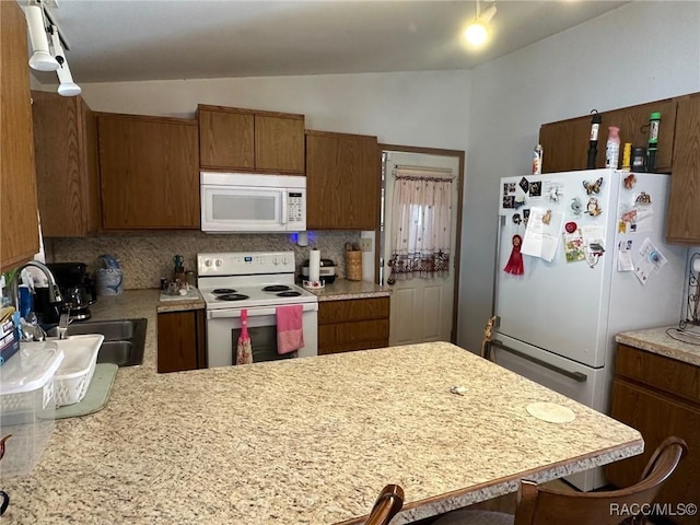 kitchen featuring white appliances, light countertops, backsplash, and a sink