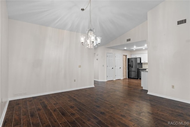 unfurnished living room featuring a notable chandelier, vaulted ceiling, and dark hardwood / wood-style floors