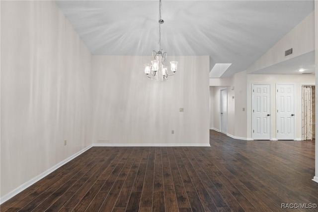 unfurnished room featuring lofted ceiling, dark hardwood / wood-style floors, and a chandelier