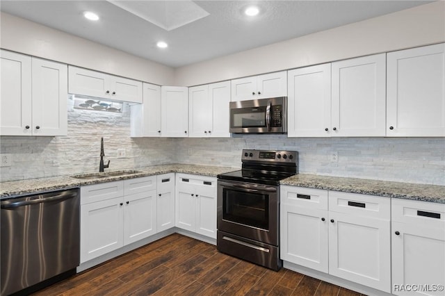 kitchen featuring tasteful backsplash, sink, white cabinets, stainless steel appliances, and dark wood-type flooring