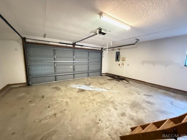 2098 W Deer Trail Ln, Lecanto, FL 34461 - garage featuring a garage door opener, baseboards, and electric panel