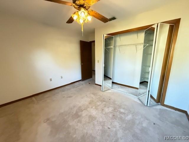 unfurnished bedroom with ceiling fan and a closet