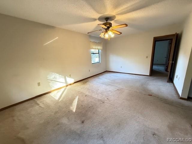 spare room featuring light carpet, a textured ceiling, and ceiling fan