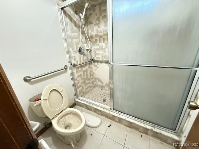 bathroom featuring tile patterned floors, toilet, and walk in shower