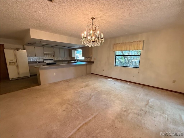 2098 W Deer Trail Ln, Lecanto, FL 34461 - kitchen featuring white refrigerator with ice dispenser, range with electric stovetop, a peninsula, a chandelier, and dark countertops