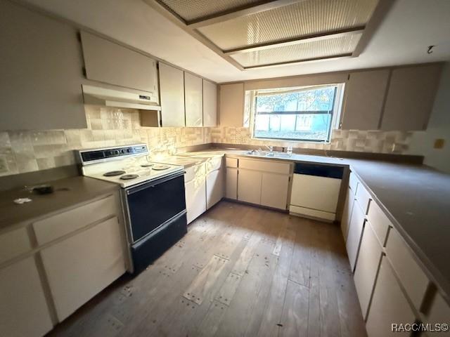 kitchen featuring white cabinets, light wood-type flooring, white appliances, and backsplash