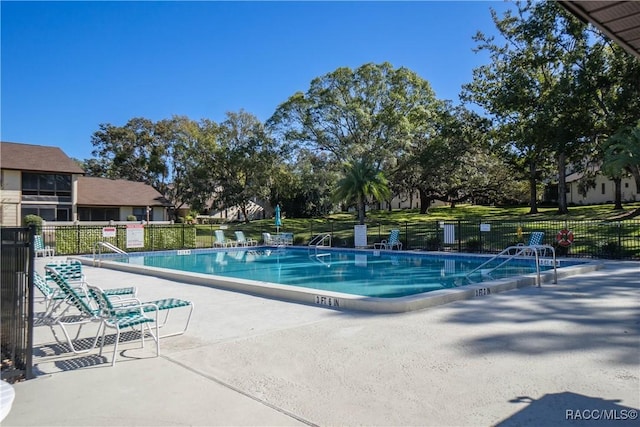 community pool with fence and a patio