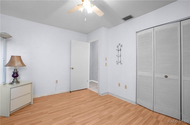 unfurnished bedroom with a closet, visible vents, light wood-style floors, ceiling fan, and baseboards