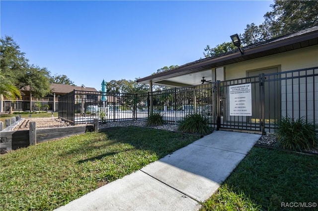 surrounding community featuring a gate, fence, and a lawn