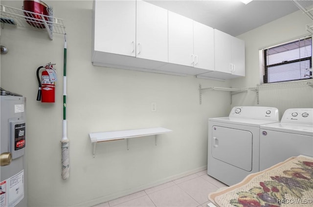 laundry room featuring light tile patterned floors, cabinet space, washing machine and dryer, and electric water heater