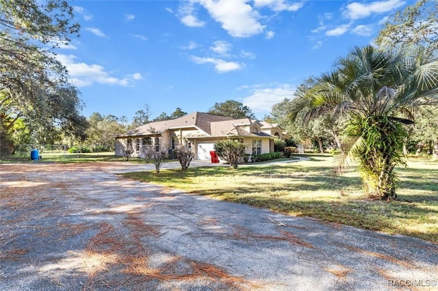 view of front of home featuring a front yard, driveway, and an attached garage