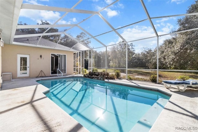 pool with a patio and glass enclosure