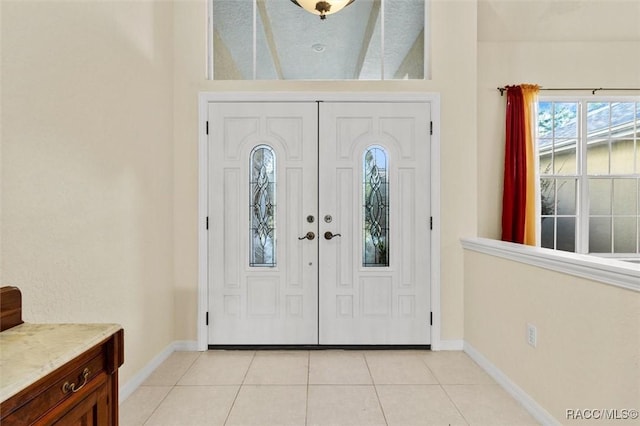 foyer featuring light tile patterned flooring and baseboards