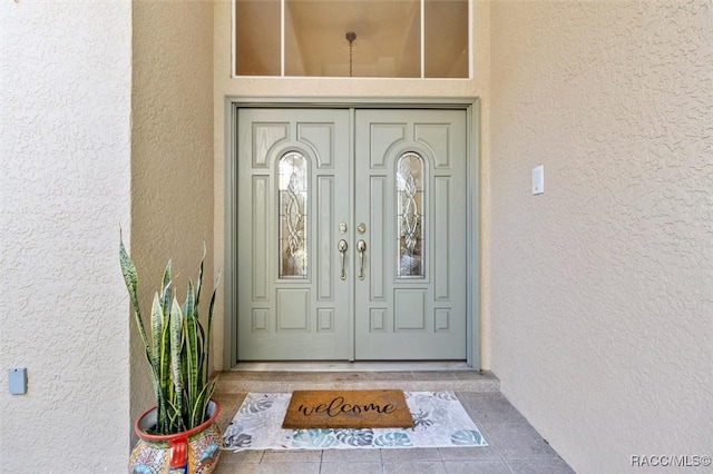 entrance to property featuring stucco siding