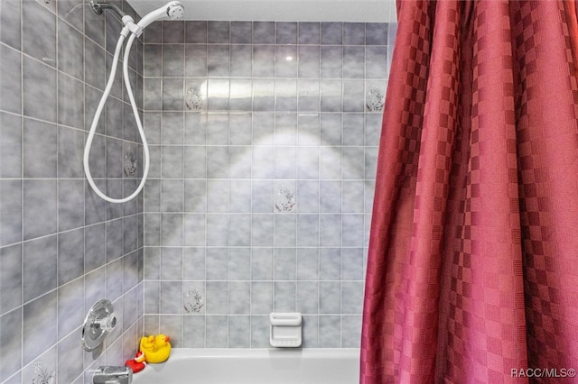 bathroom with shower / bath combo with shower curtain