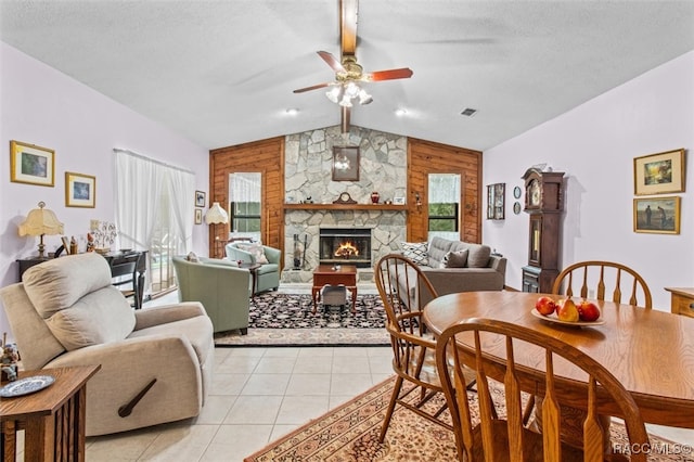 dining room with ceiling fan, a fireplace, lofted ceiling with beams, and a textured ceiling