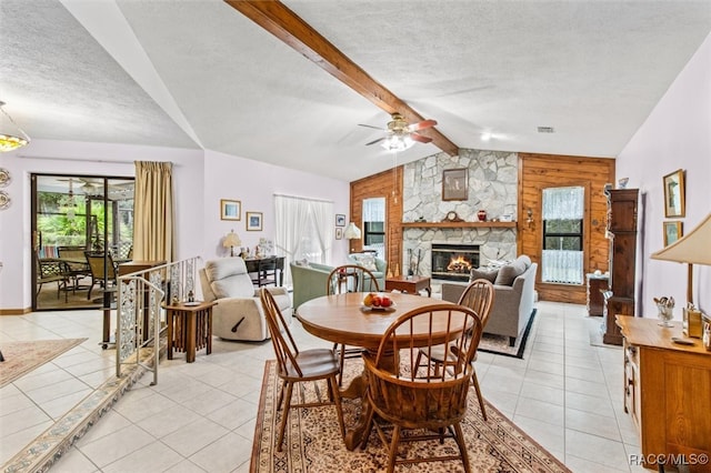 dining space with vaulted ceiling with beams, plenty of natural light, and a textured ceiling