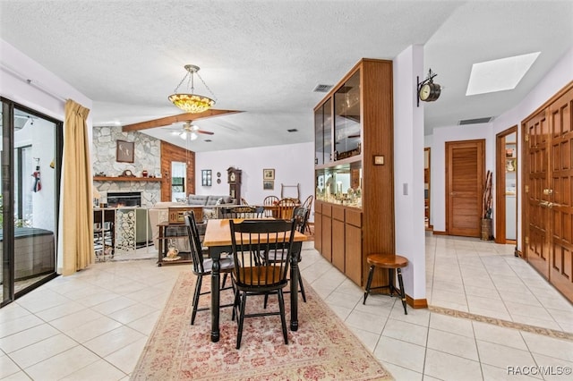 dining space featuring light tile patterned floors, a textured ceiling, plenty of natural light, and ceiling fan