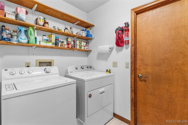 clothes washing area with light tile patterned flooring and independent washer and dryer