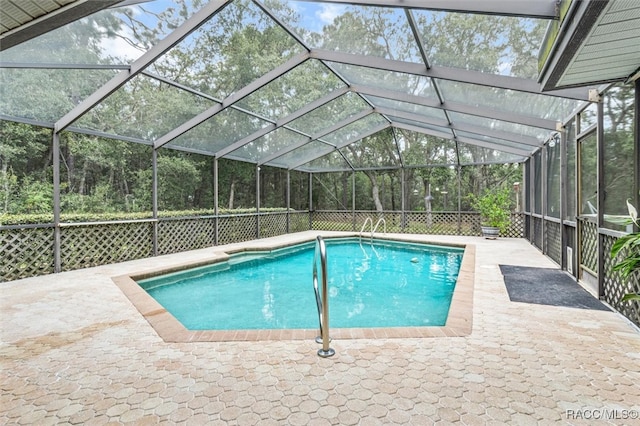 view of swimming pool featuring a lanai and a patio