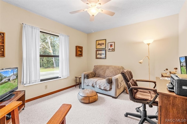 carpeted home office featuring ceiling fan