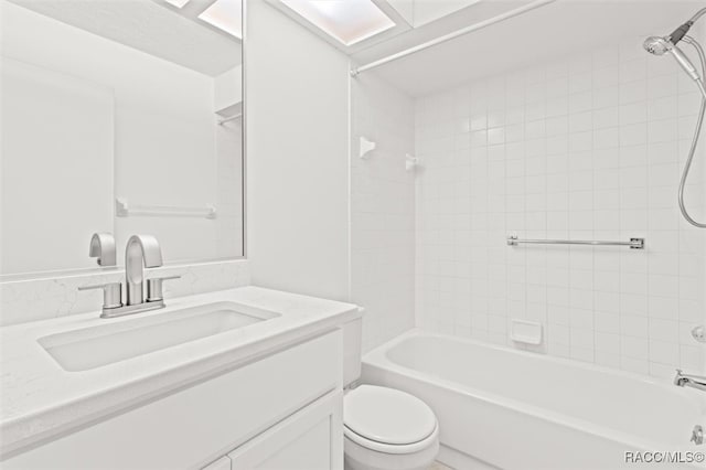 full bathroom featuring tiled shower / bath, vanity, and toilet