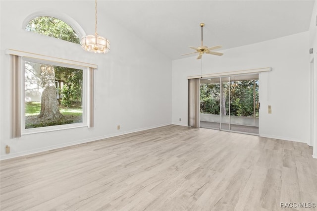 interior space with high vaulted ceiling, light hardwood / wood-style floors, and ceiling fan with notable chandelier