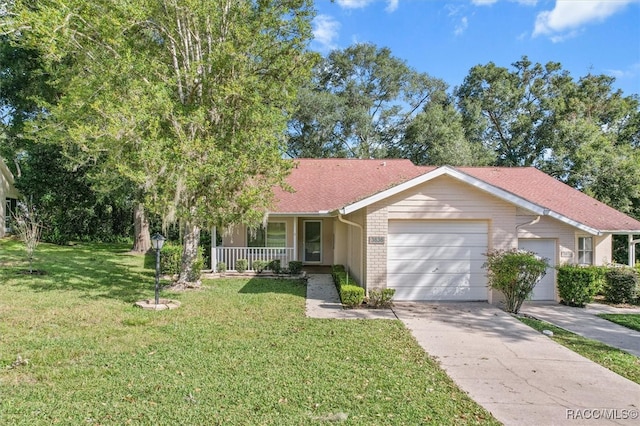 view of front of home featuring covered porch, a garage, and a front lawn