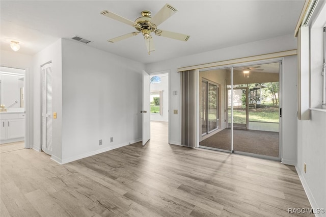 spare room featuring light hardwood / wood-style flooring, ceiling fan, and a healthy amount of sunlight