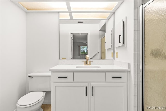 bathroom featuring vanity, toilet, and walk in shower